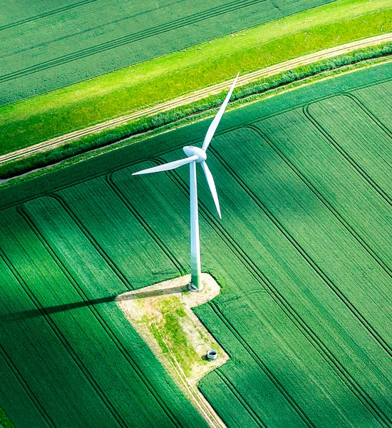 Wind turbine on a farm amid green fields