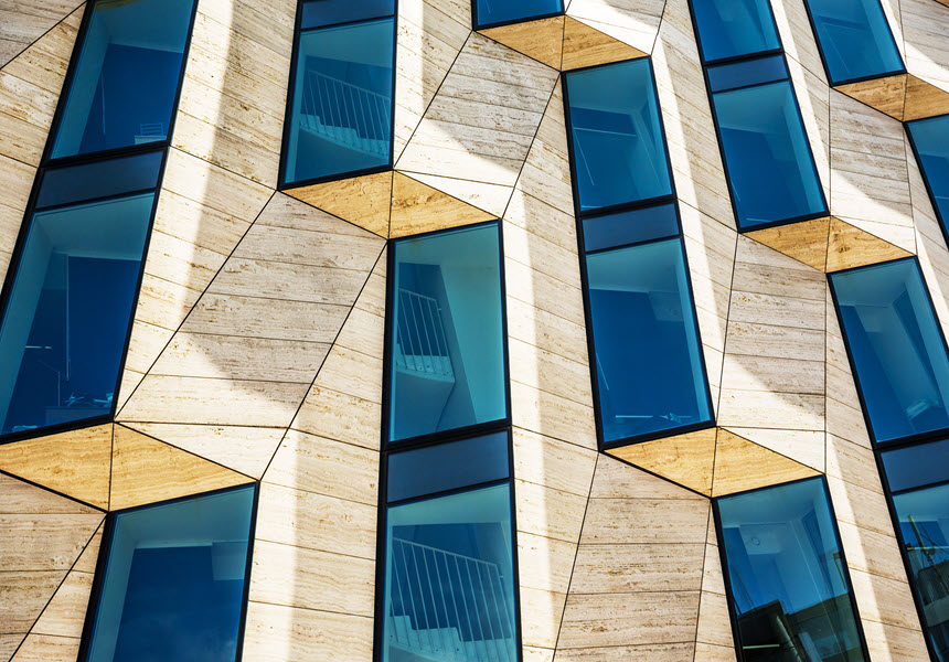 Modern office building with repeating rectangle design and blue windows.