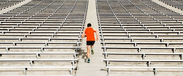 A man with orange sports top running up the stairs