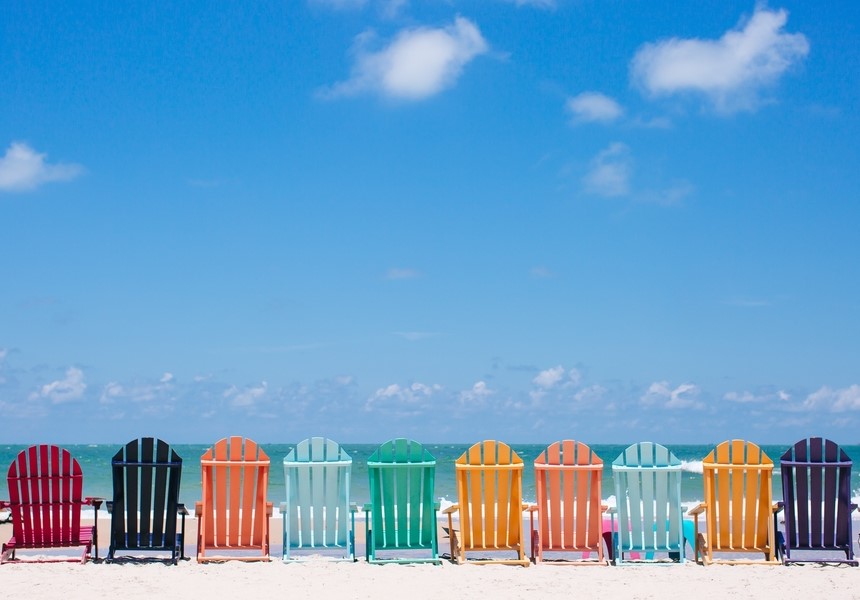 沙灘上有不同顏色的椅子