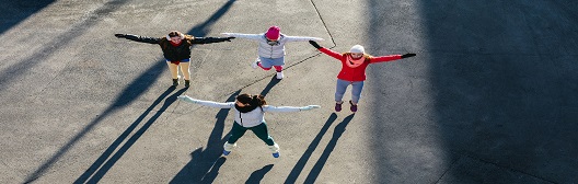 一群人站成一圈，手拉着手，举起双臂庆祝