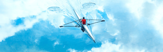 person in rowing boat surfing in water