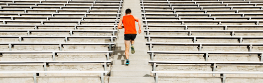 Man running up a set of bleachers