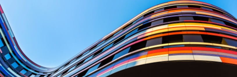 Curved building with bright colors against a blue sky