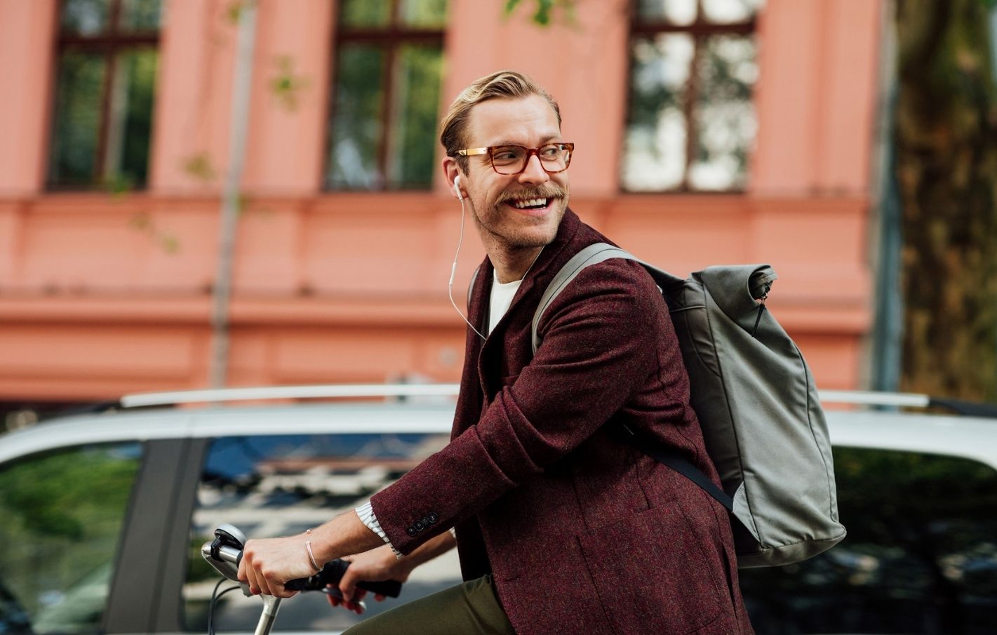 Man riding a bike in the city looking over his shoulder
