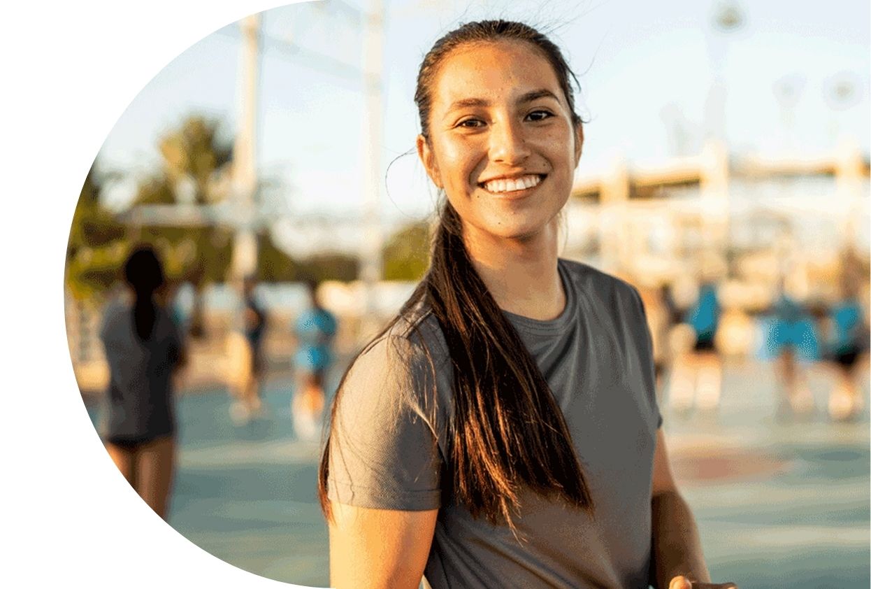 brunette girl smiling and playing netball