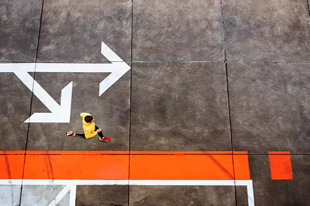 Person walking across a surface marked with directional arrows, symbolizing different investment paths and portfolio choices.