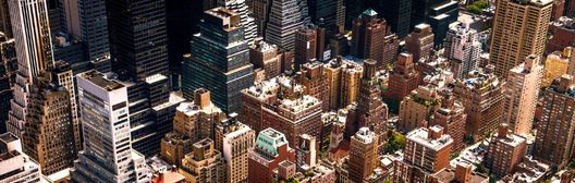 Aerial view of a dense city centre with high-rise office and residential buildings.