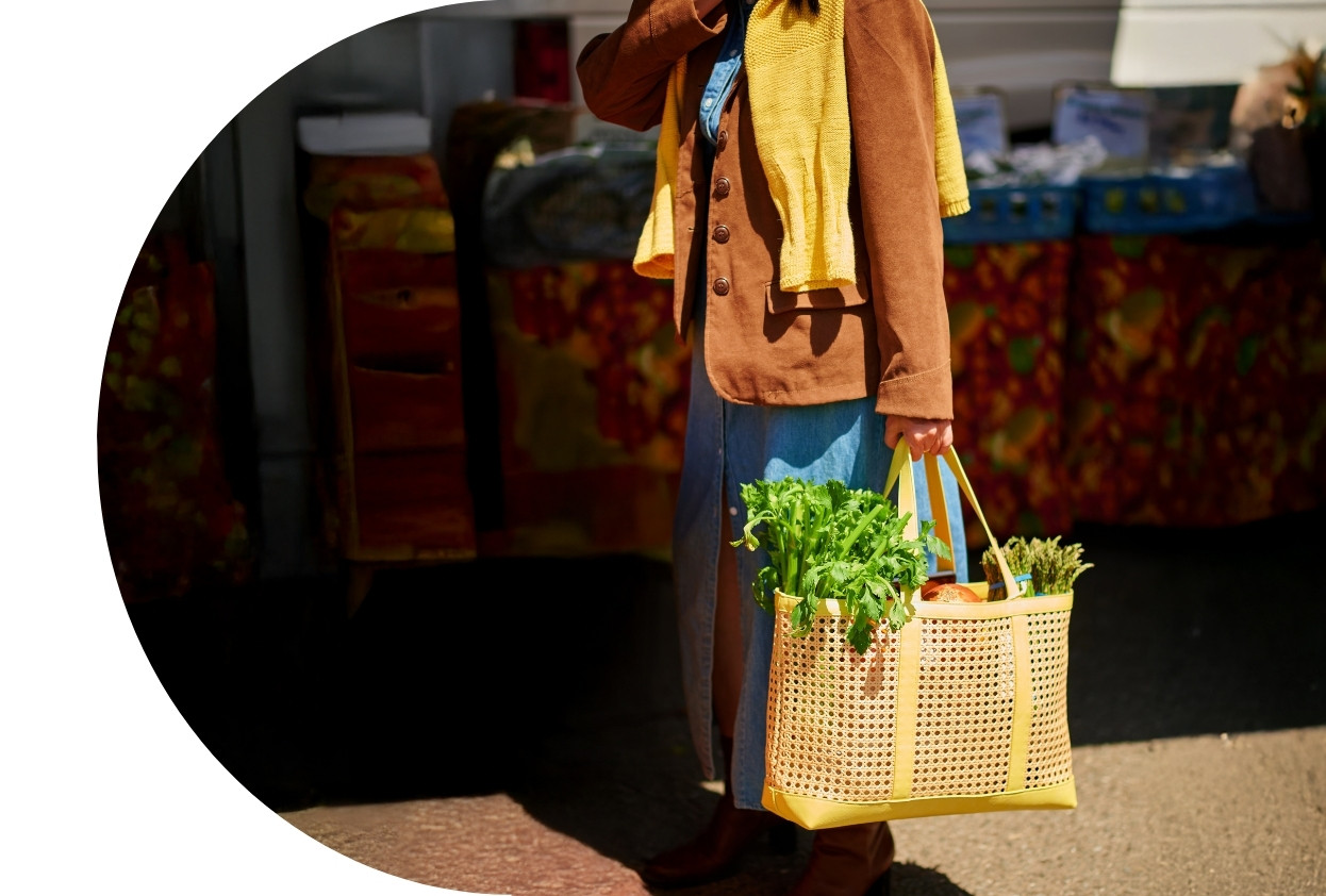 Lady in blazer carrying grocery bag.