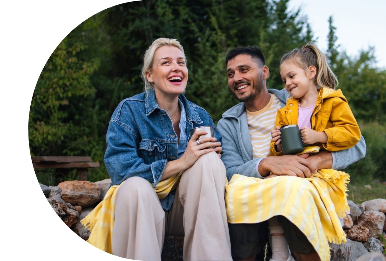 Smiling family wrapped in yellow blanket
