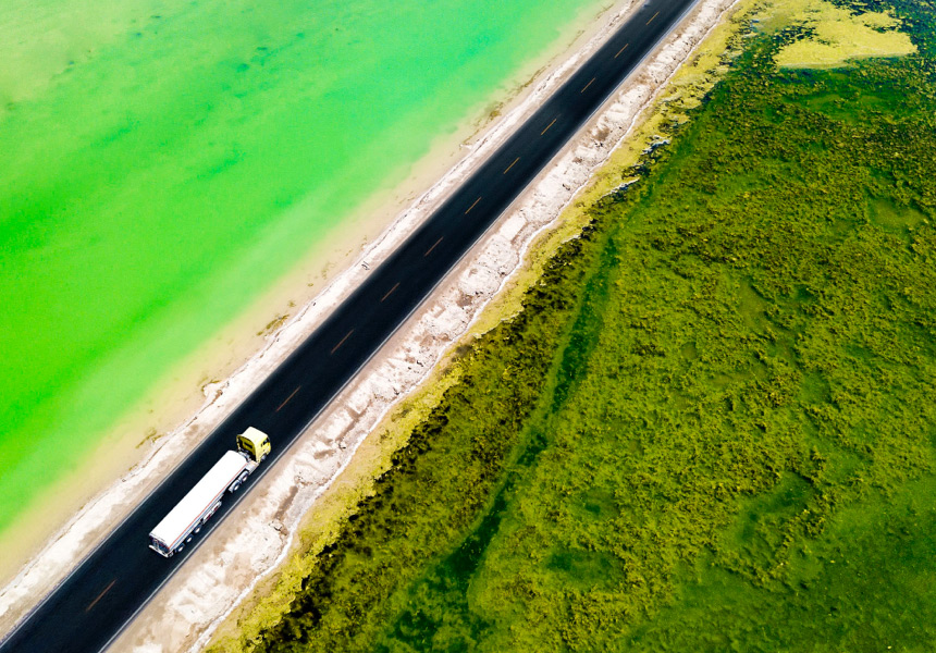 A bird’s eye view of a tractor trailer driving up the coastline