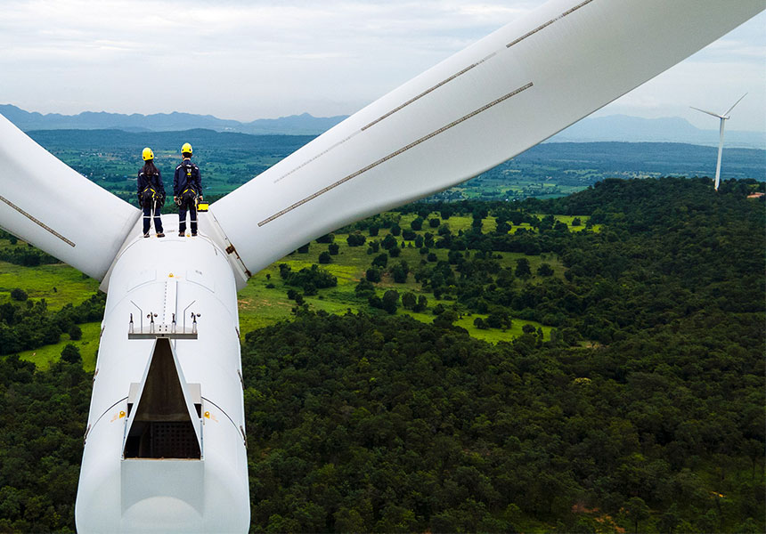 worker standing on top of a windmill