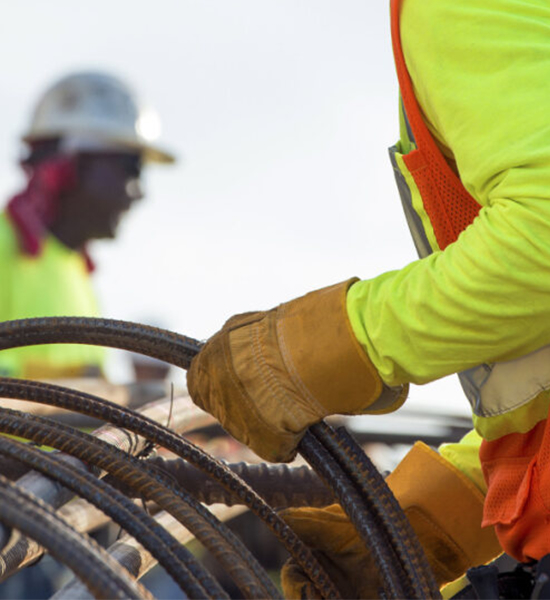 Construction workers handling steel rebar on a job site