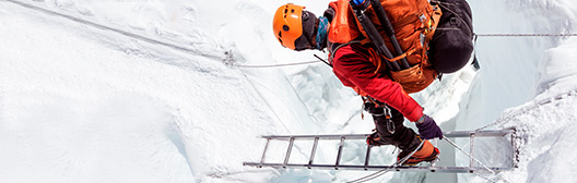 Climber crossing a crevice on a ladder