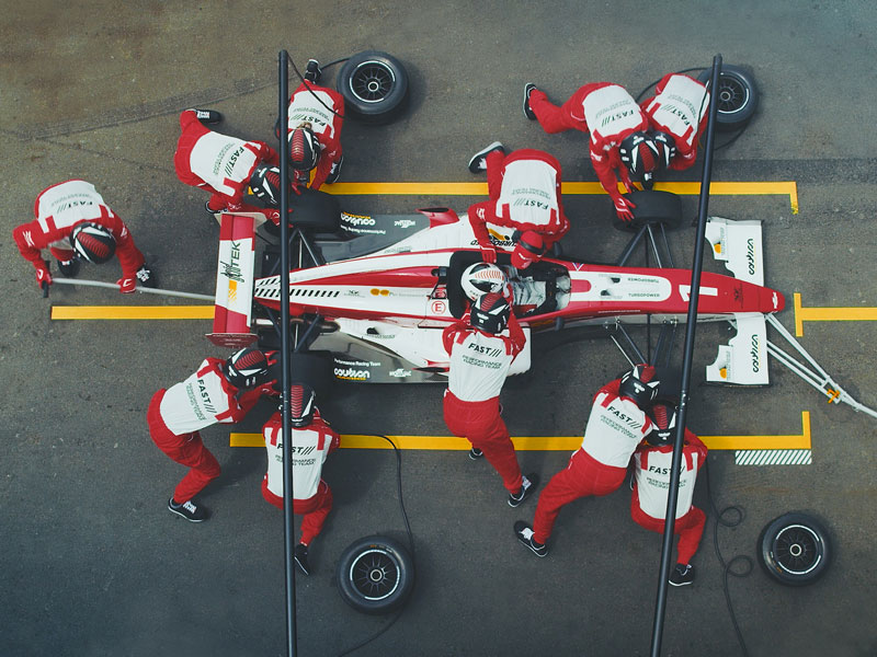 Formula one team assembling car 