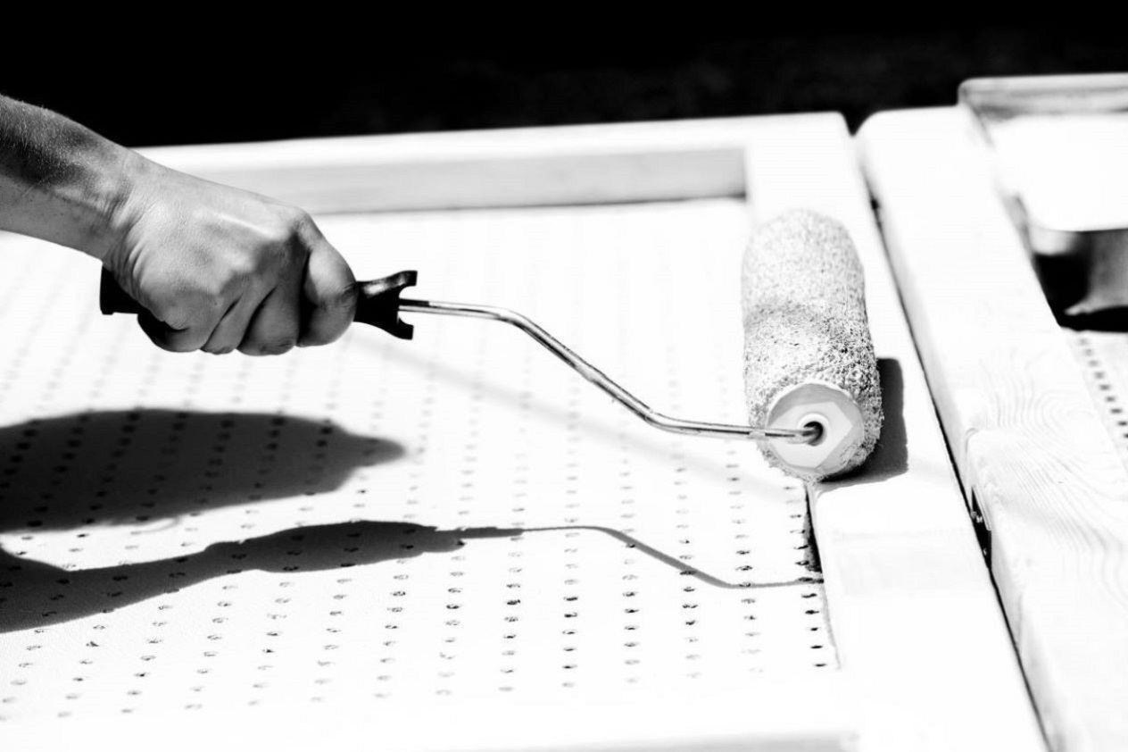 Women painting wall with roller
