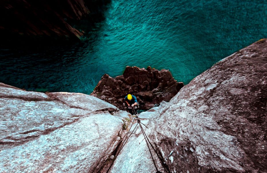 Harnessed Climber Descending Cliff
