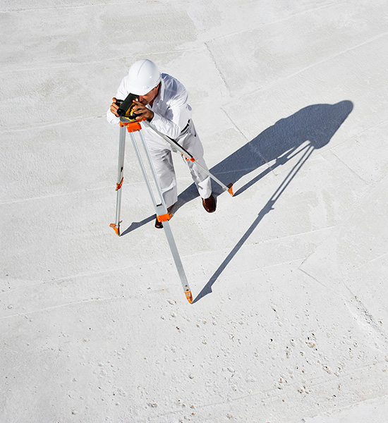 An image of a man dressed in all white looking through binoculars on a stand