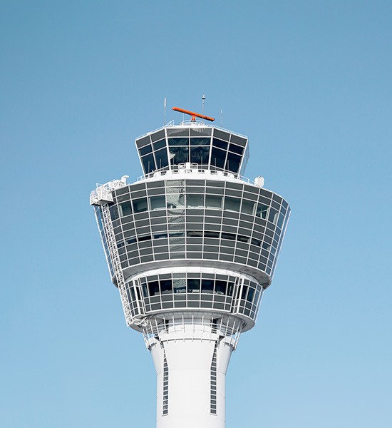 An image of a tall white pole with a circular building on top with windows 