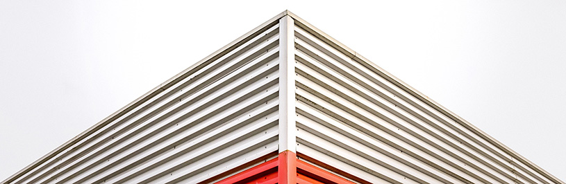 Image of the edge of a building. The bottom of the building is red and the top of the building is white