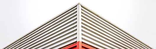 Image of the edge of a building. The bottom of the building is red and the top of the building is white