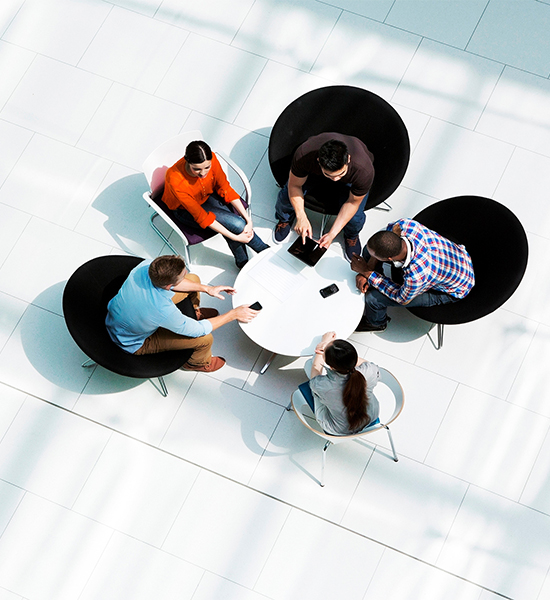 Colorful photo of people in an open plan office having a meeting