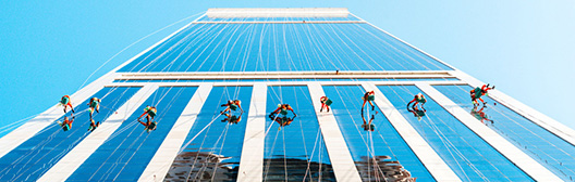 Men hanging off the side of a tall building