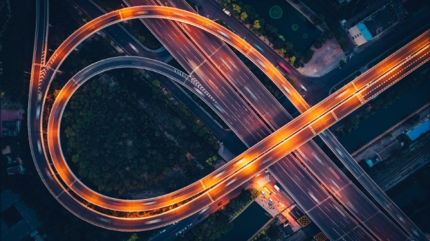 Aerial view of a brightly lit highway interchange with looping overpasses at night