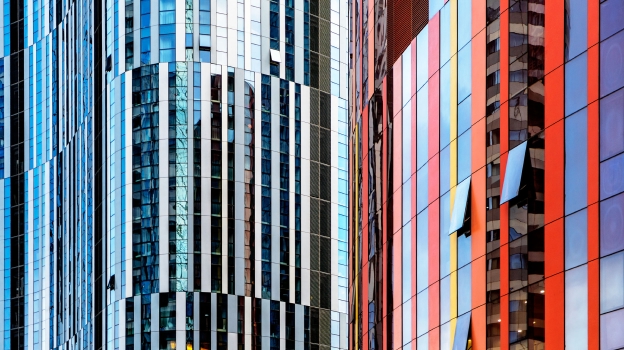 Modern building facade with reflective glass panels and vertical metal fins