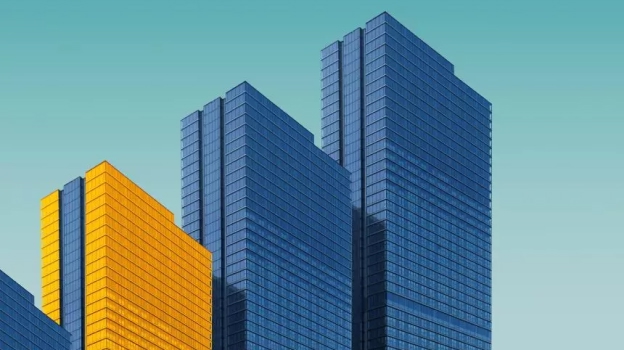 Modern office buildings with glass facades, including one building with a yellow exterior