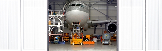 Image of a plane in a hanger getting mechanical servicing