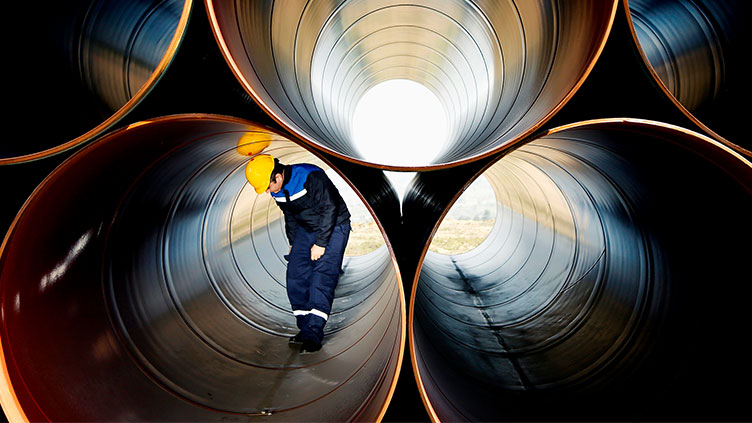 Journeyman inspecting large pipes