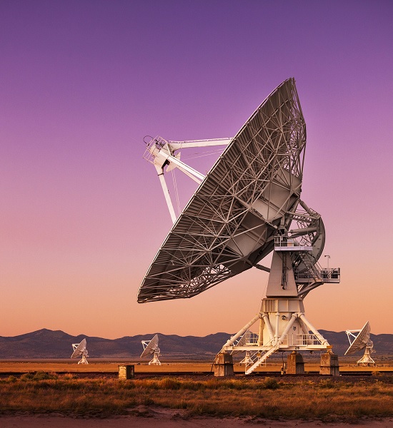 Communication satellite in a field at dusk