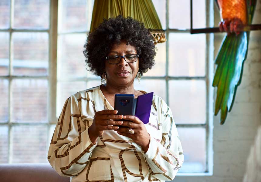 Curly hair women wearing specs checking her phone