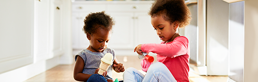 girls playing on floor in kitchen