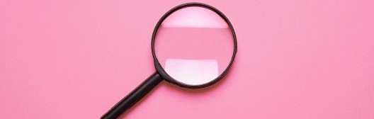 Magnifying glass on pink background