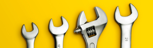 Four wrenches in ascending order of size over abright yellow background