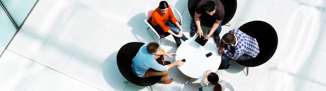 Overhead view of individuals at a table, symbolizing collaboration and effective communication in retirement planning discussions