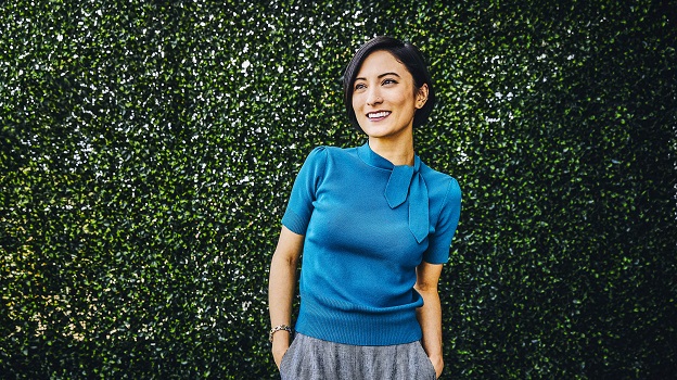 Woman smiling against a green backdrop