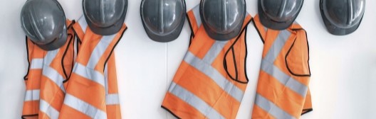 Hardhats and vests hanging on a wall