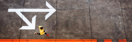 Jogger alongside arrows on pavement.