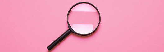 magnifying glass against pink background