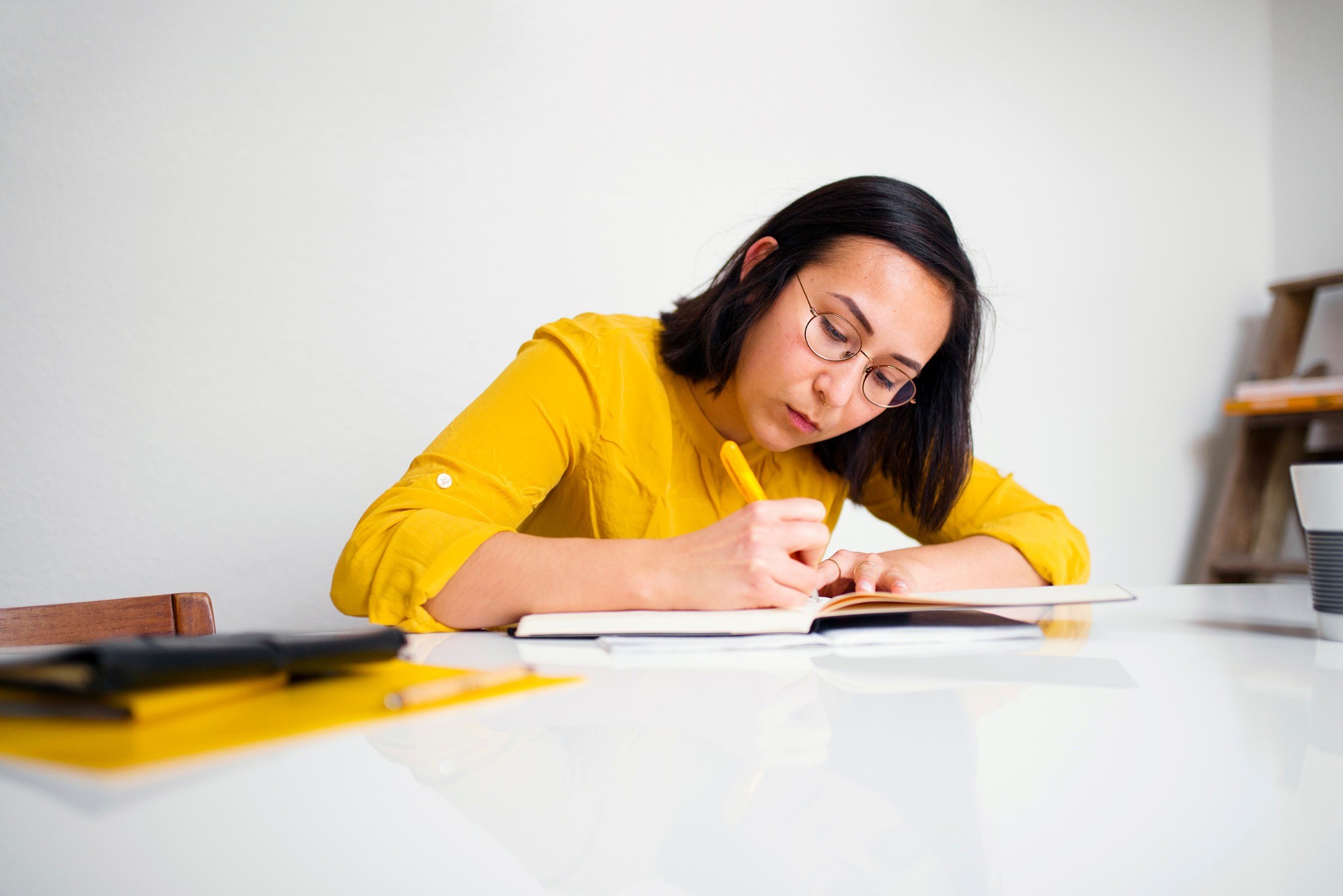 Woman taking notes for an educational video series on retirement planning and saving strategies.