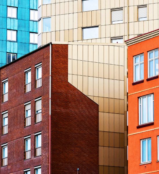Colorful residential building facades with varied materials and window patterns.