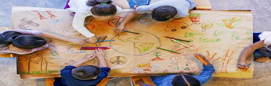 Kids sitting at a table and drawing pictures