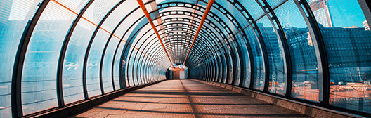 Curved glass pedestrian tunnel with city views