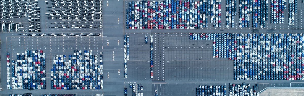Aerial view of a large parking lot filled with rows of parked cars.