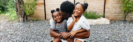 Person hugging two young children