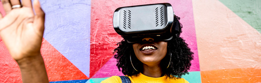 Person interacting with virtual reality technology in front of a vibrant, multicolored wall.