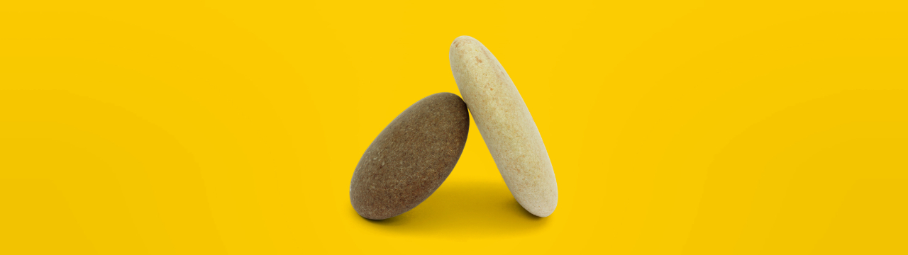Two rocks balanced against one another symbolize the building blocks of improved retirement plans through public policy.